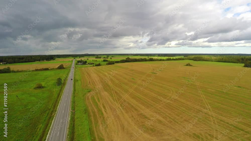 Cars passing driving to the horizon. Green fields and clouds. Aerial footage. Cars passing driving to the horizon. Green fields and clouds. Aerial footage.