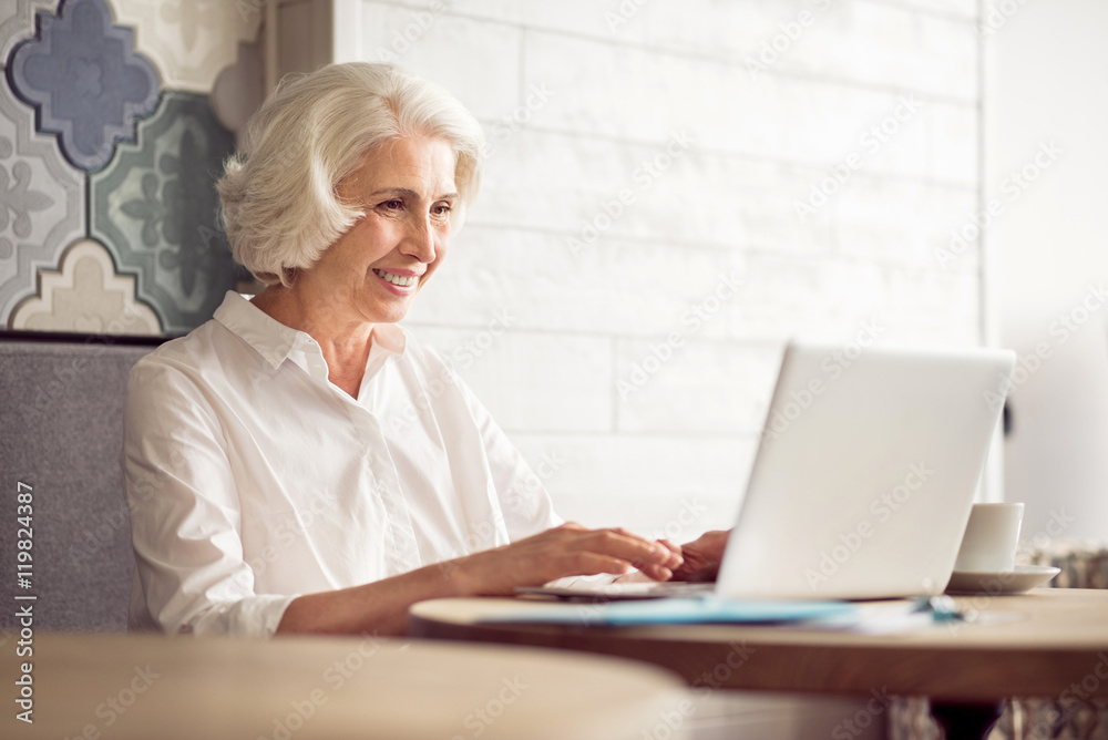 Cheerful delighted woman using laptop Cheerful delighted woman using laptop
