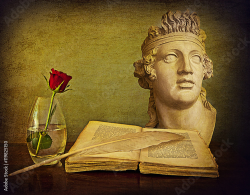Romantic still life, antique book, quill, red rose, marble bust
