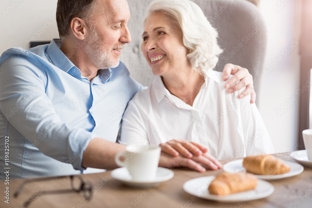 Joyful loving couple sitting at the table Joyful loving couple sitting at the table