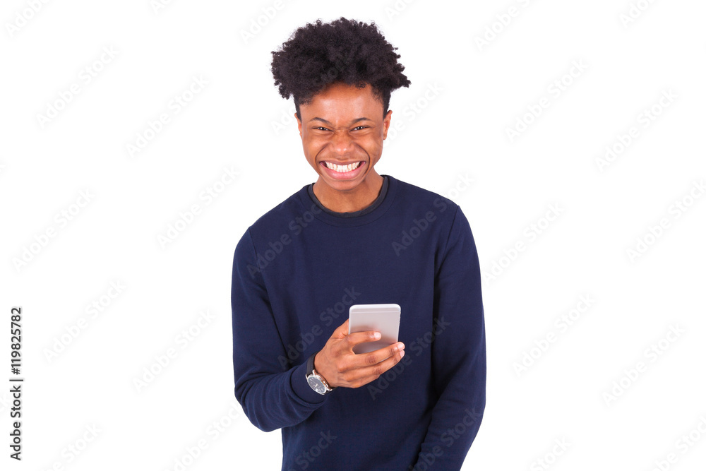 Young African American man sending a sms text message on his sma Young African American man sending a sms text message on his sma