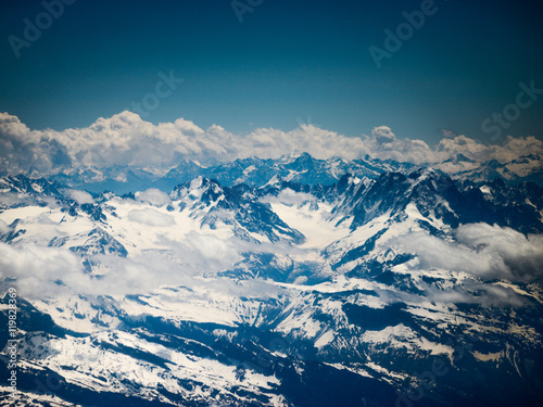 Winter landscape of mountains with snow under blue cloudy sky