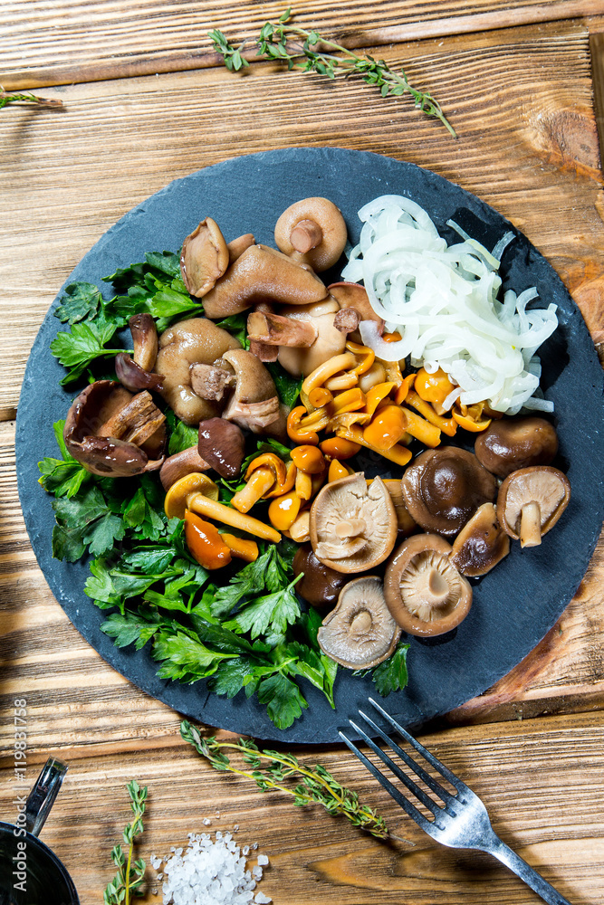 Fototapeta premium Beautiful different mushrooms with herbs and onions