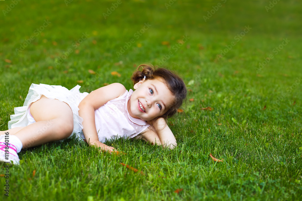 little girl lying on the grass and laughing little girl lying on the grass and laughing