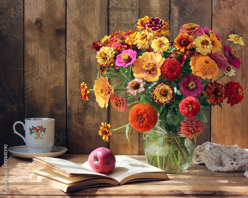 Fotografie Bouquet of garden flowers, an Apple and a book.
