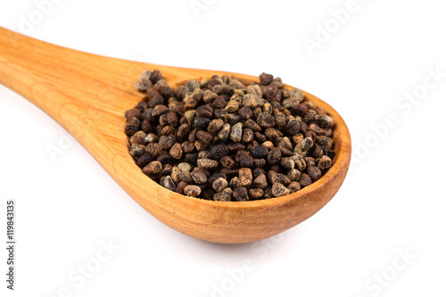 Decorticated cardamom seeds in a wooden spoon