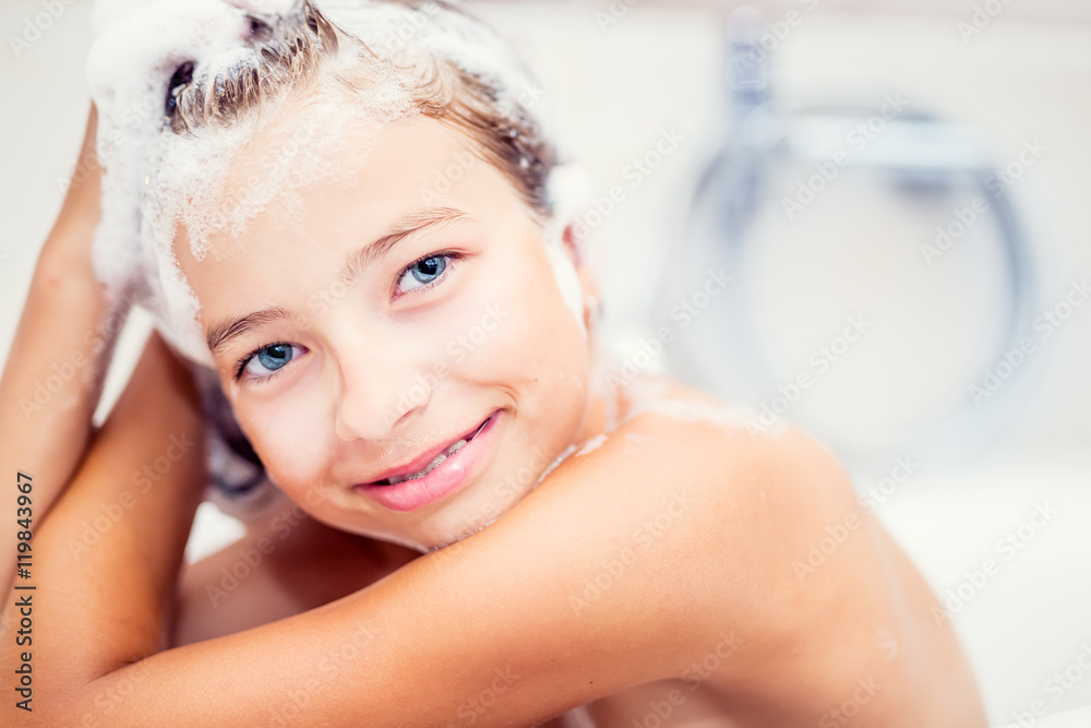 Foto Stock Cute young girl in shower washing hair and face with shampoo. |  Adobe Stock