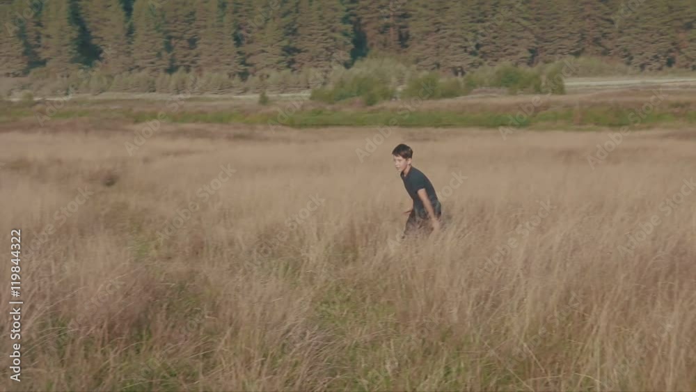 Little boy playing soccer in the field. Child running through meadow with a ball. Countryside and forest Little boy playing soccer in the field. Child running through meadow with a ball. Countryside and forest