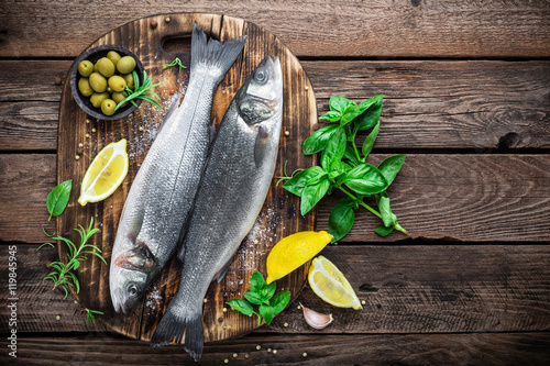 Bilde på lerret raw seabass fish on wooden background top view