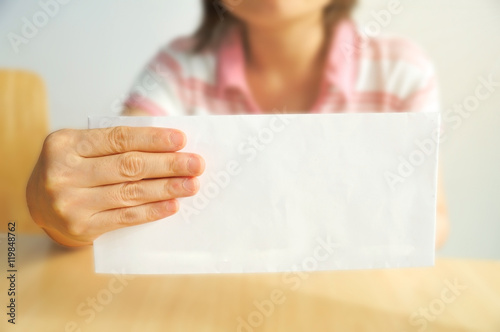 Middle Asian woman hold long envelope on left hand