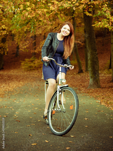 Young girl is riding bike in the park.