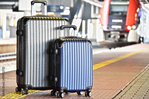Two plastic travel suitcases on the railroad platform