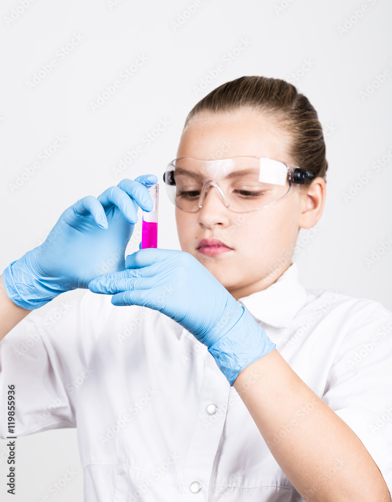 Attentive schoolgirl conducting a chemistry experiment at elementary science class Attentive schoolgirl conducting a chemistry experiment at elementary science class