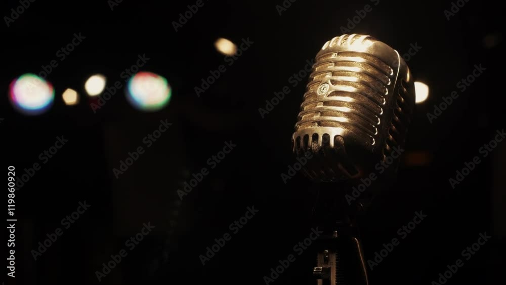 Concert vintage glare microphone on stage in empty retro club. White spotlights. Close up.