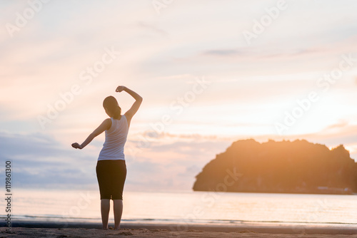Relaxed woman breathing fresh air at on the beach sunrise. © THE YOOTH