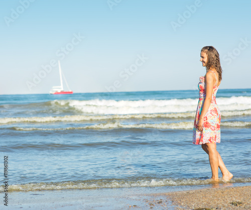 Girl in dress walking on the beach