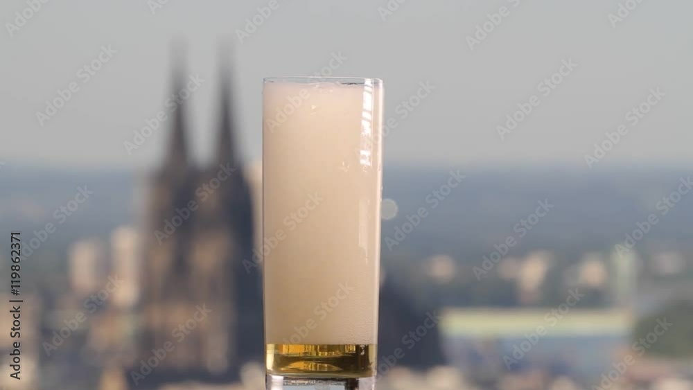 famous german beer called Kölsch pouring in a beer glas in front of the cologne cathedral