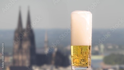 famous german beer called Kölsch pouring in a beer glas in front of the cologne cathedral