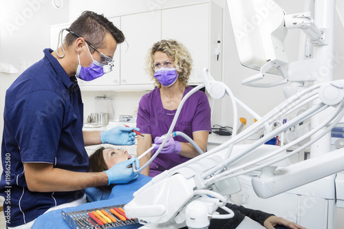 Dentist And Assistant Examining Patient Together