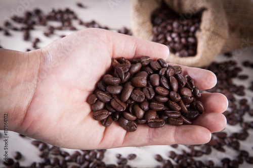close up coffee bean on hand of human with coffee bean in sack b