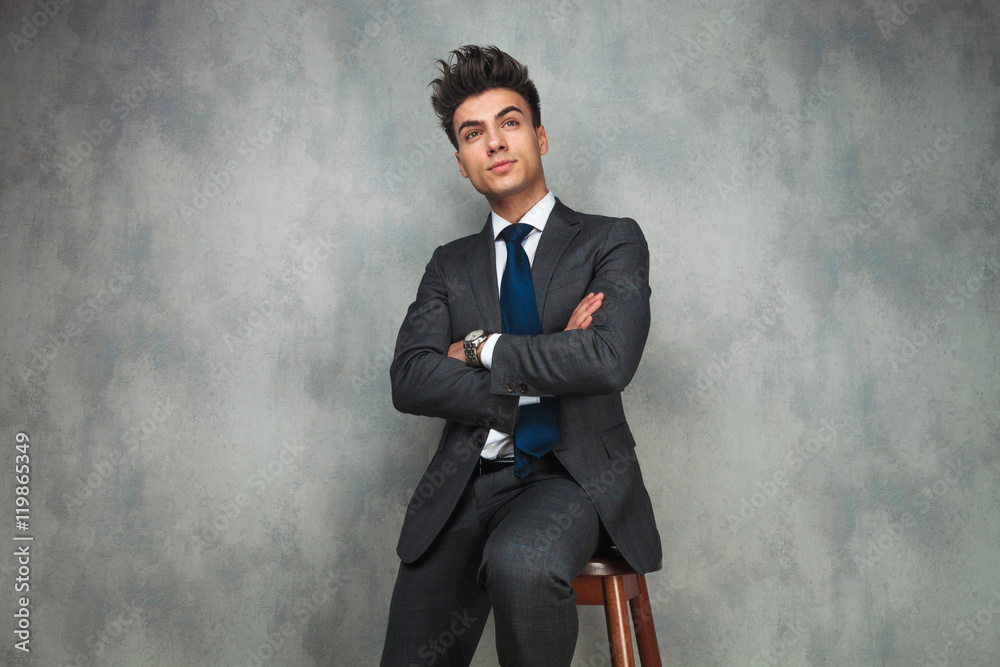 seated young businessman dreaming away with hands crossed seated young businessman dreaming away with hands crossed