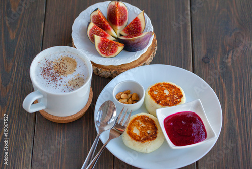 Cappuccino and cottage cheese pancakes with figs and jam for breakfast on wooden background. Sweet figs.