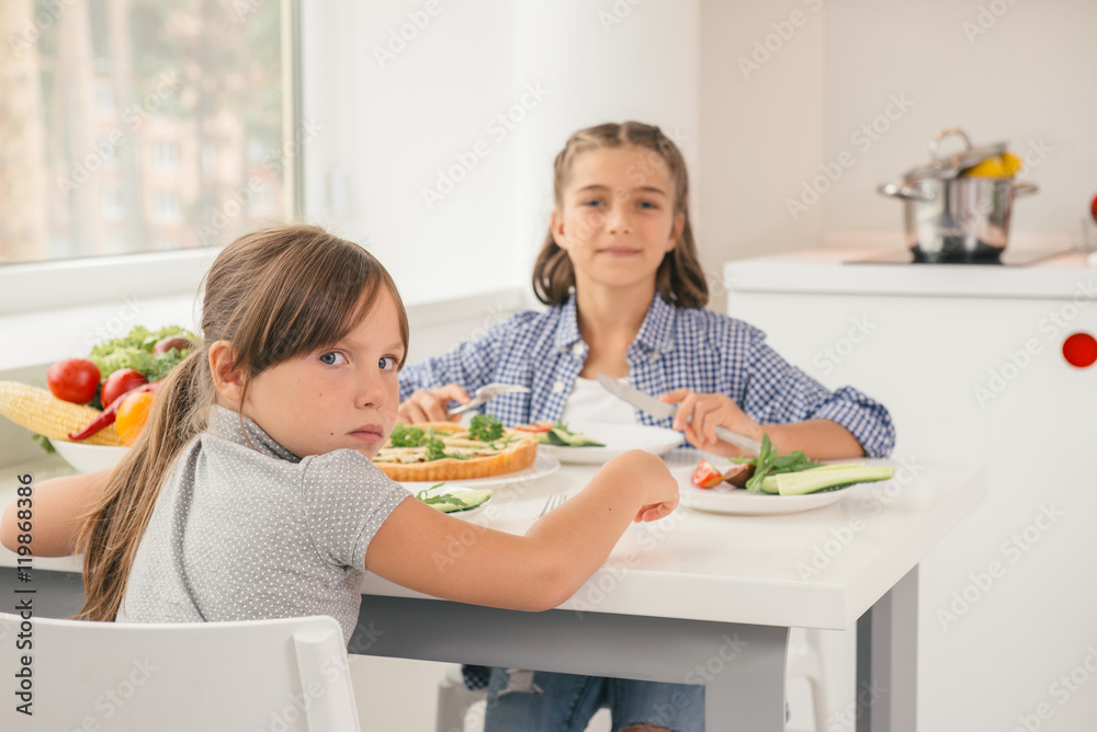 Hungry little girl by the table
