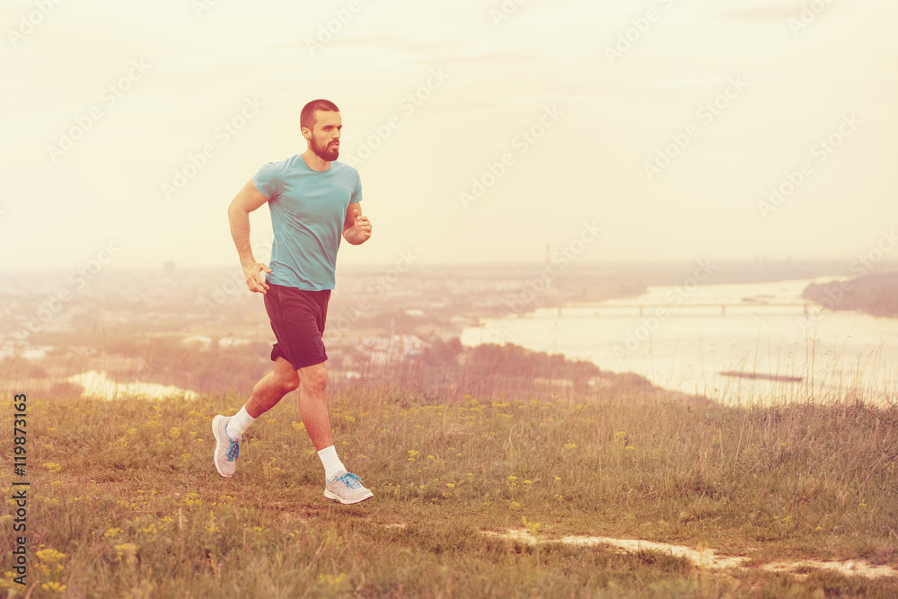 Athletic young man running in the nature. Healthy lifestyle Athletic young man running in the nature. Healthy lifestyle