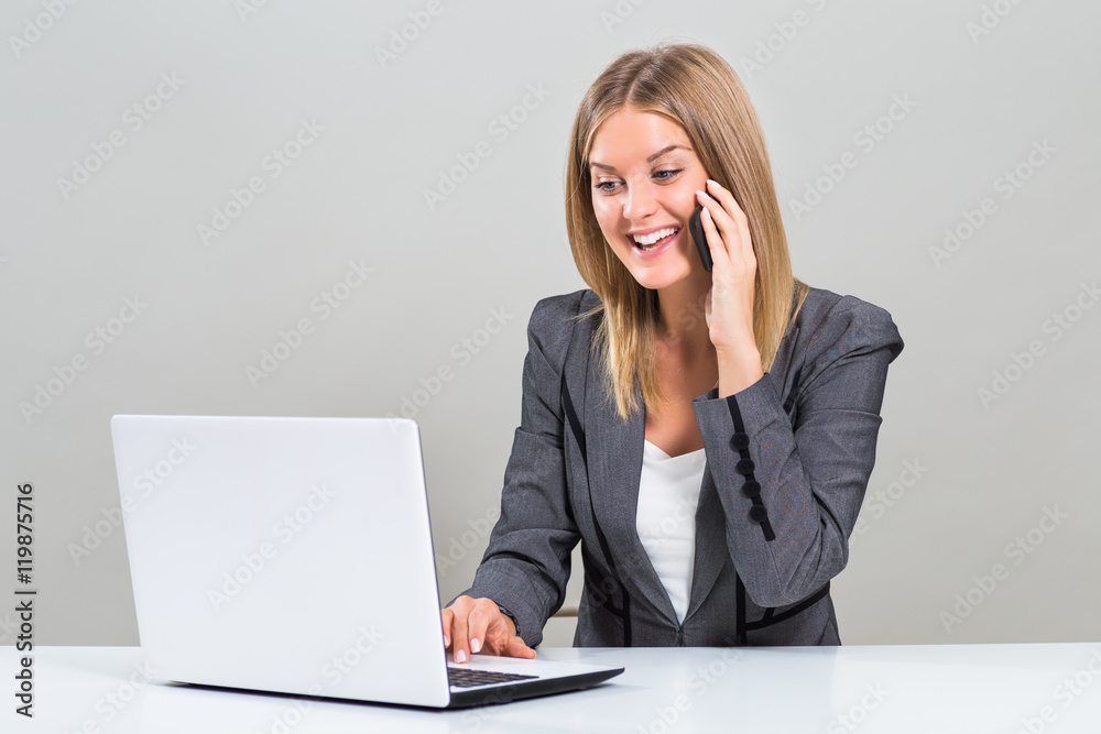 Beautiful businesswoman is sitting at the table,using laptop and talking on the phone.
Beautiful businesswoman is sitting at the table,using laptop and talking on the phone.