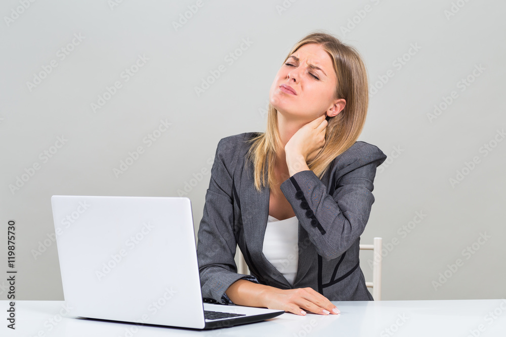 Beautiful businesswoman is having pain in her neck while she is working.
Beautiful businesswoman is having pain in her neck while she is working.