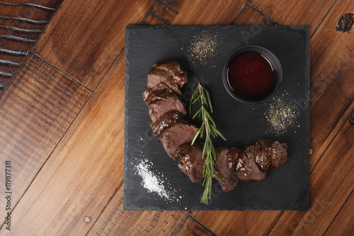 Fotografiet Grilled venison slices with rosemary and sauce