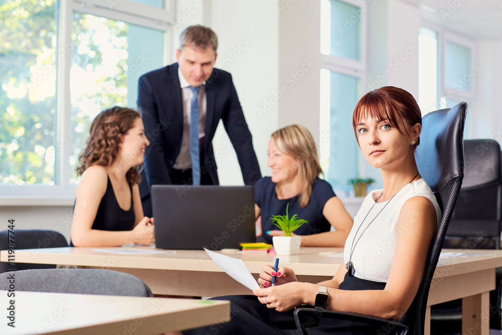 Portrait of curly business woman in the office in a chair on the