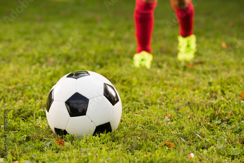 Aspiring young kid is seen training soccer / football on a local football field. © urbans78