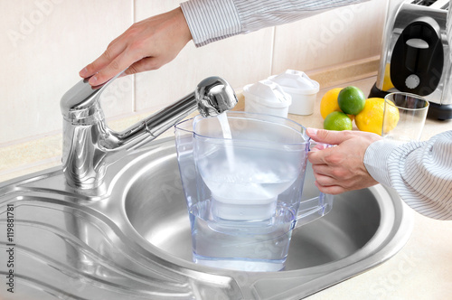 Man pours water into water filter jug