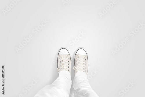 Person taking photo of his foots stand on blank floor, isolated, top view, clipping path. Ground design mock up. Man wear gumshoes and watching down. Deck flooring mockup template. photo