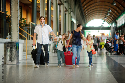 Young family with two children at train station.