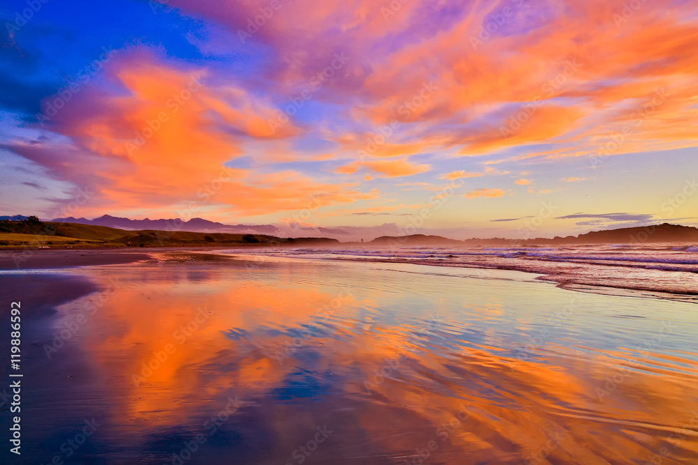 Sandy beach and orange clouds in Westport, New Zealand Sandy beach and orange clouds in Westport, New Zealand