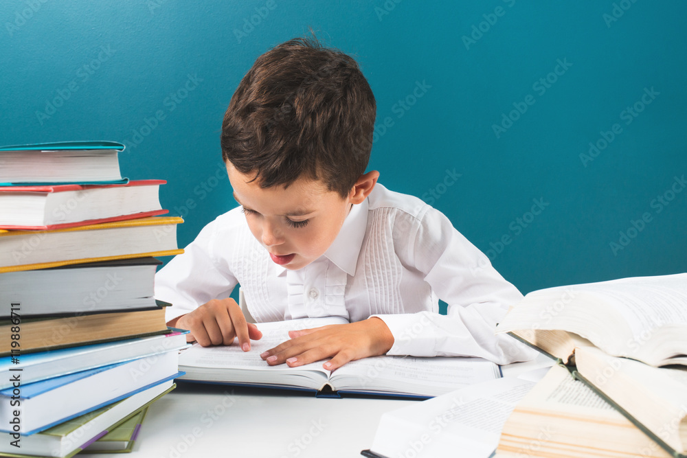 Сute boy reading book at the table Сute boy reading book at the table