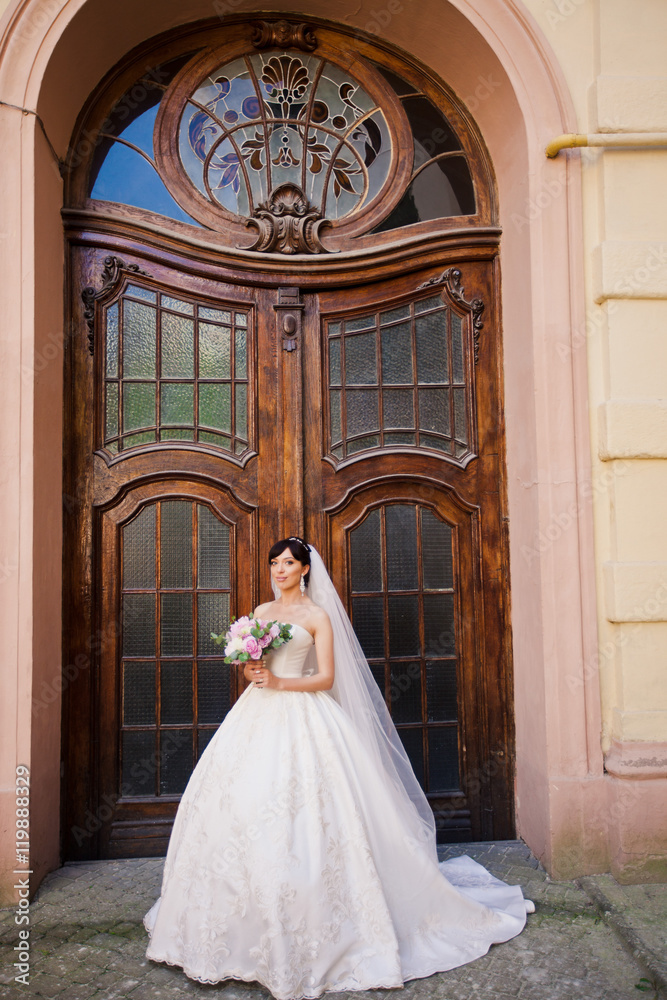 Attractive bride in amazing white dress with bouquet