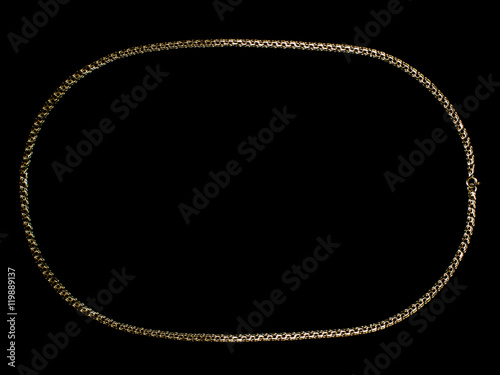 Gold necklace on black background.