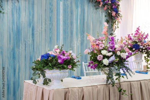 Wedding floral decorations. Flowers in vase  columns and table