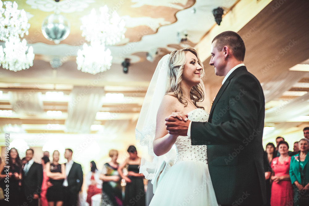 Happy bride and groom dancing alone on the dance floor their first wedding dance.