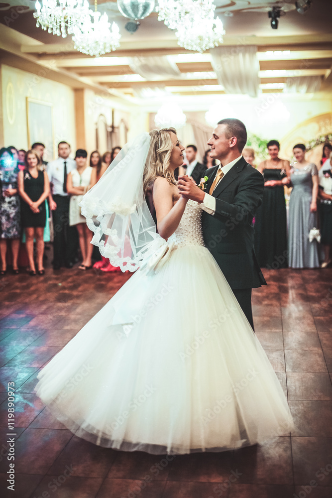 Happy bride and groom dancing alone on the dance floor their first wedding dance.