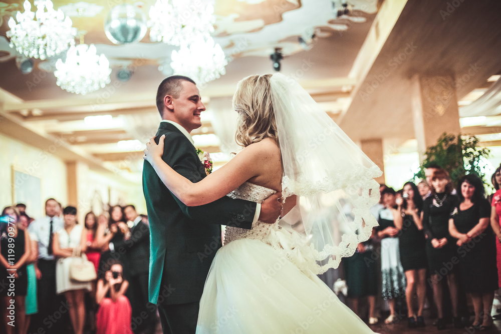 Happy bride and groom dancing alone on the dance floor their first wedding dance.
