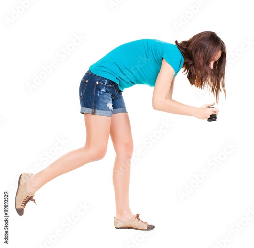 young woman in shorts photographed something compact camera. Isolated over white background. 