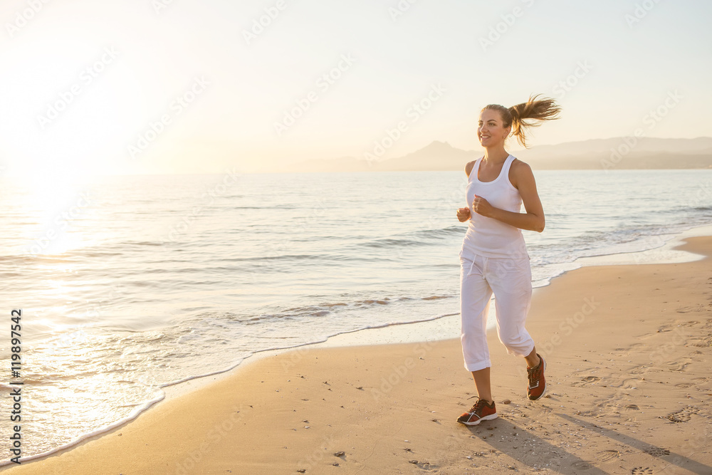 Caucasian woman jogging at seashore