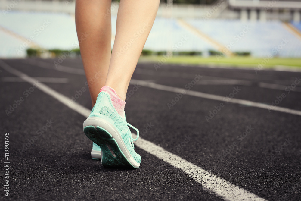 Woman wearing mint sneakers on a running stadium