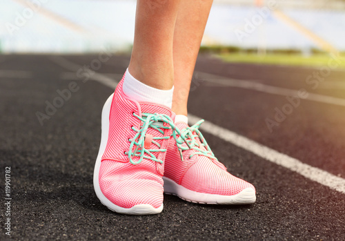 Woman wearing pink sneakers on a running stadium