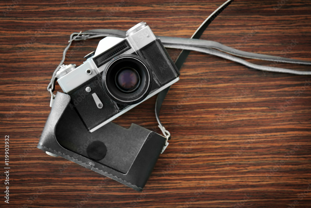 Vintage camera with case on wooden background