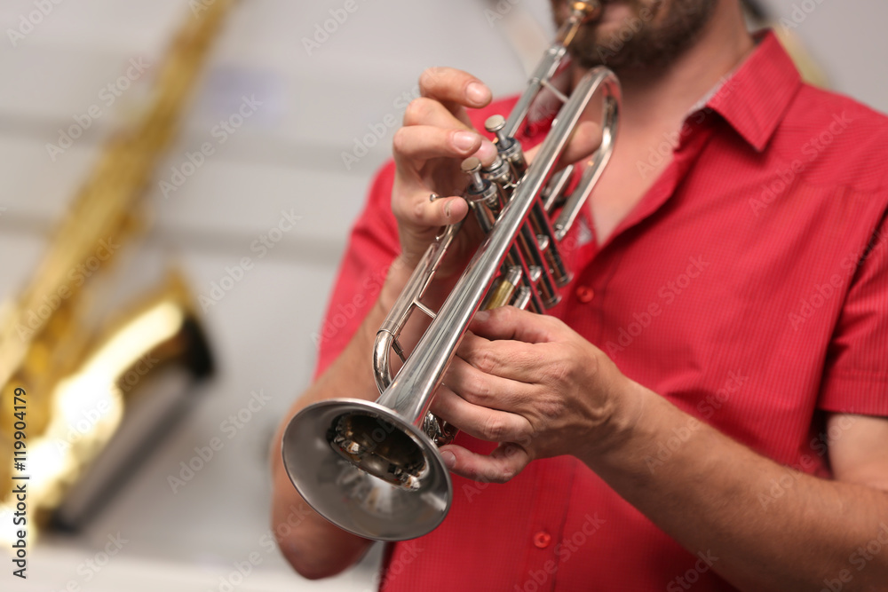 Fototapeta premium Man playing horn in music shop